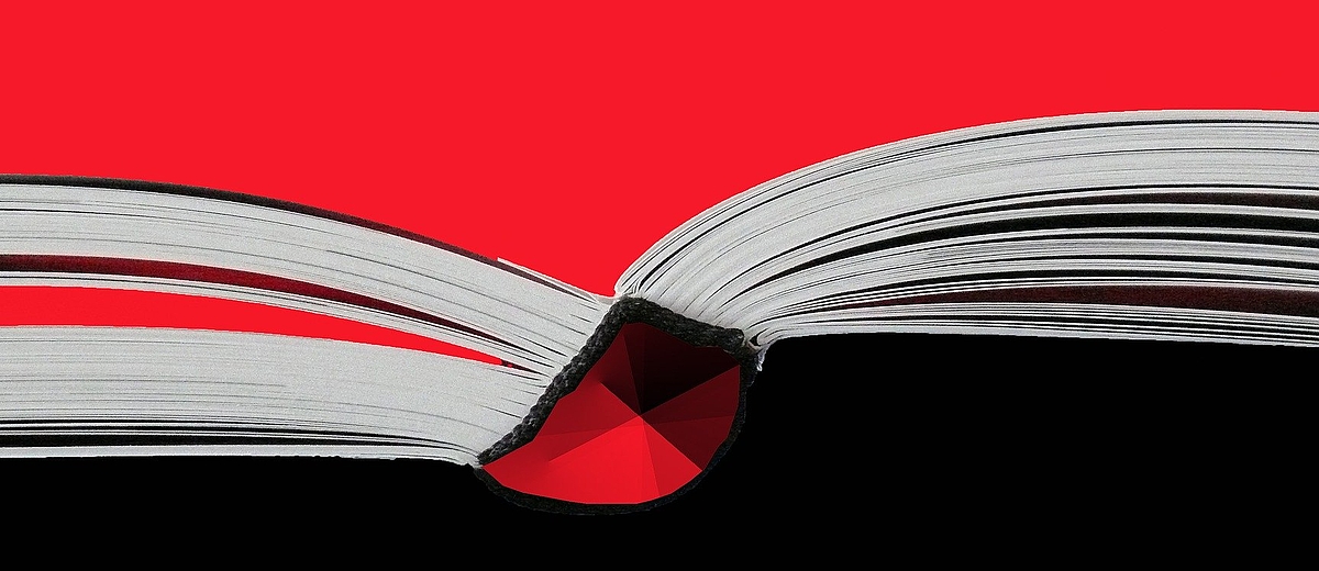 Das Bild zeigt eine künstlerische Nahaufnahme eines aufgeschlagenen Buches mit einem starken Kontrast in Rot und Schwarz.
